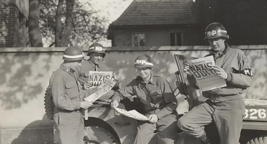 4 US MPs reading about German surrender